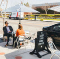 Guests eating at a cafe table mounted on Rockless Table self-stabilizing dining height bases