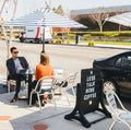 Two guests eating brunch at a cafe table mounted on Rockless Table self-stabilizing dining height bases